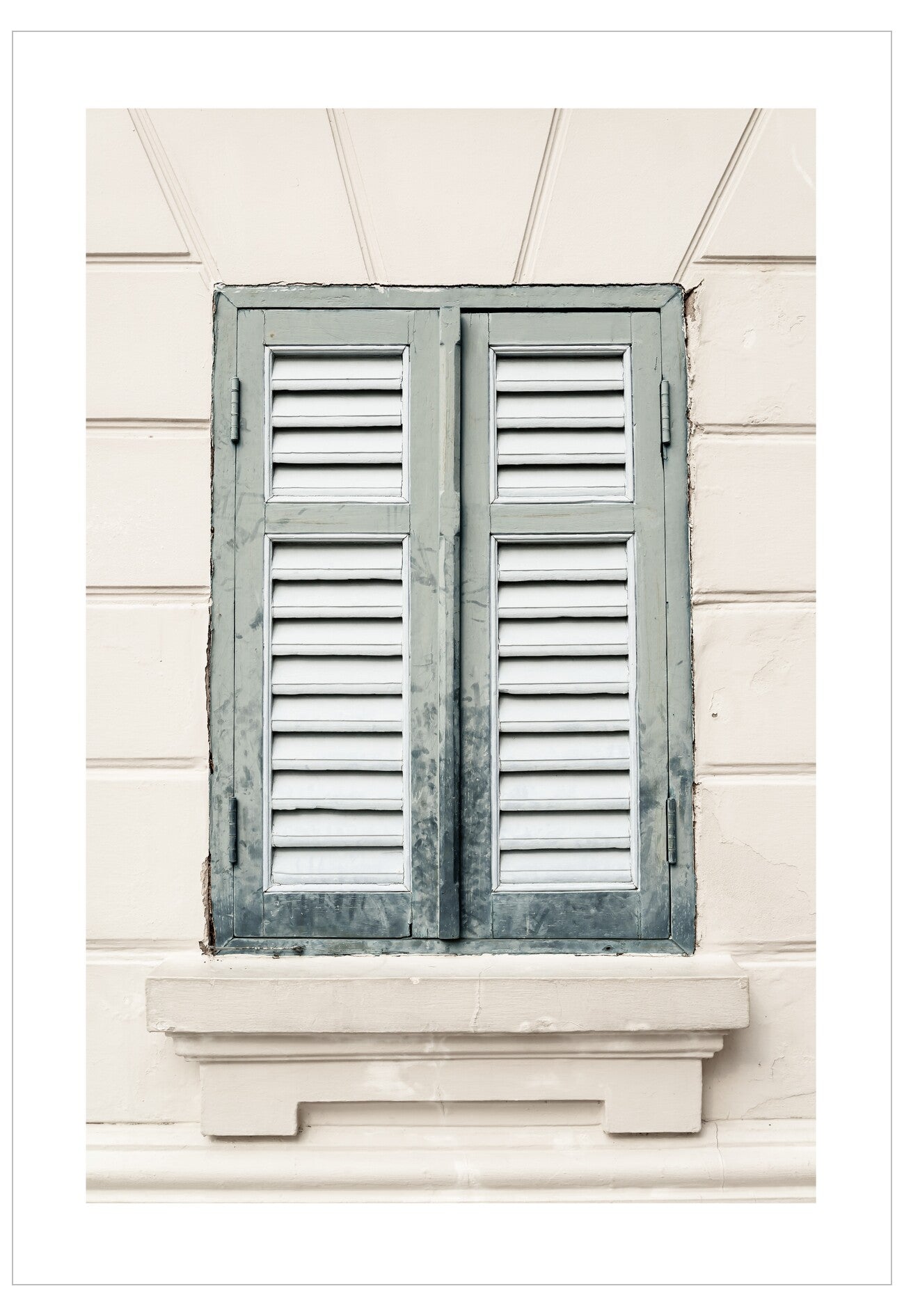 Window with wooden shutters on a light-colored wall