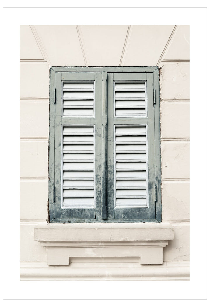 Window with wooden shutters on a light-colored wall