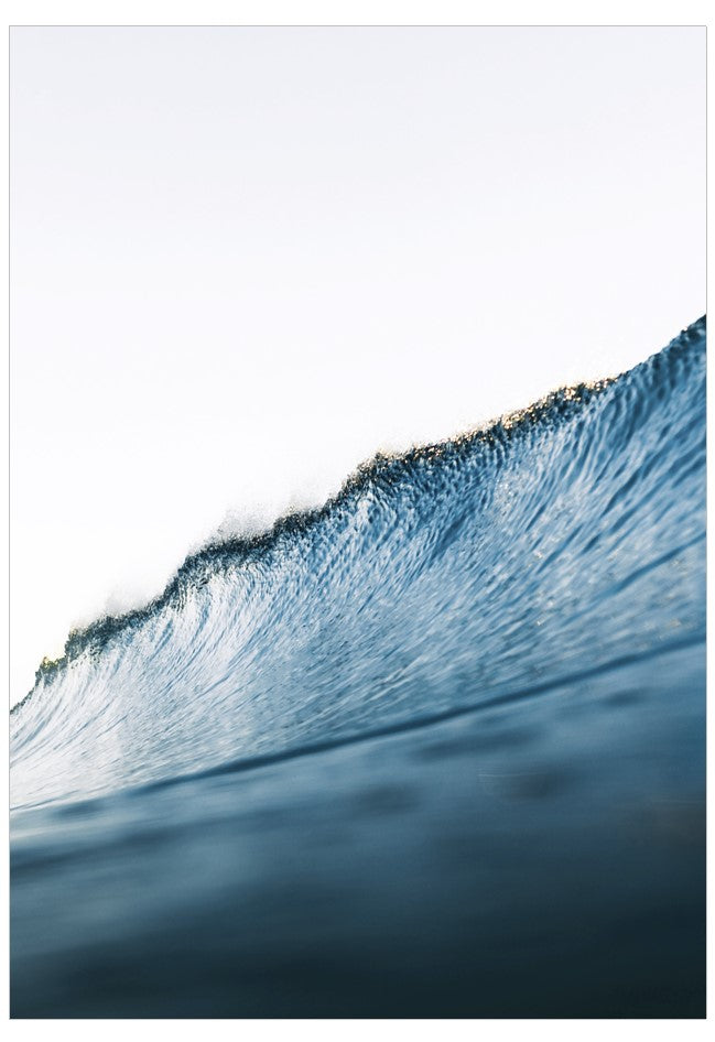 Close-up of a wave breaking with water droplets on a white background