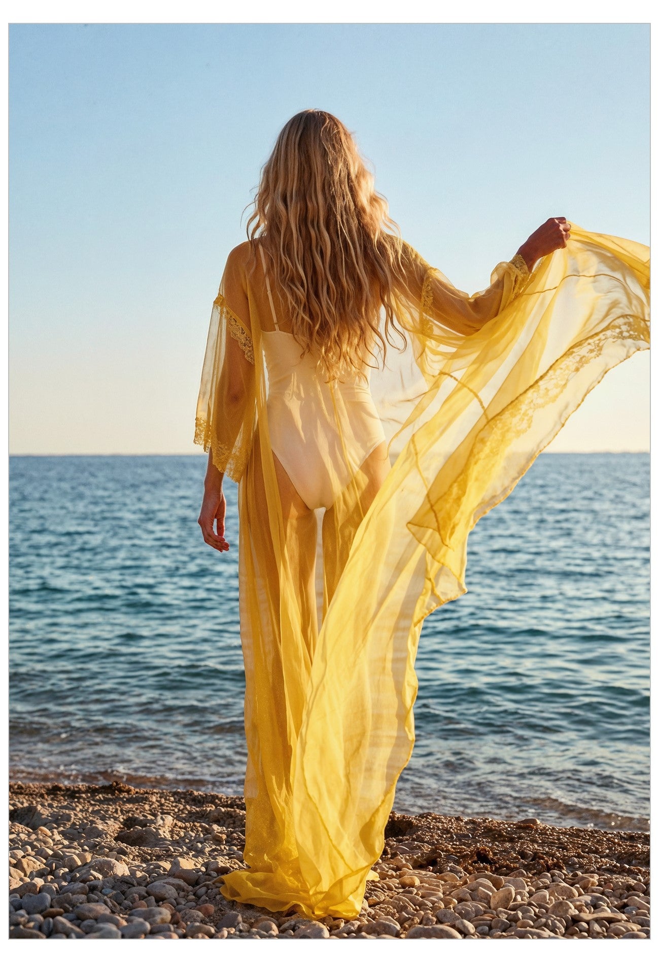 Woman in a yellow dress standing on a beach with ocean view