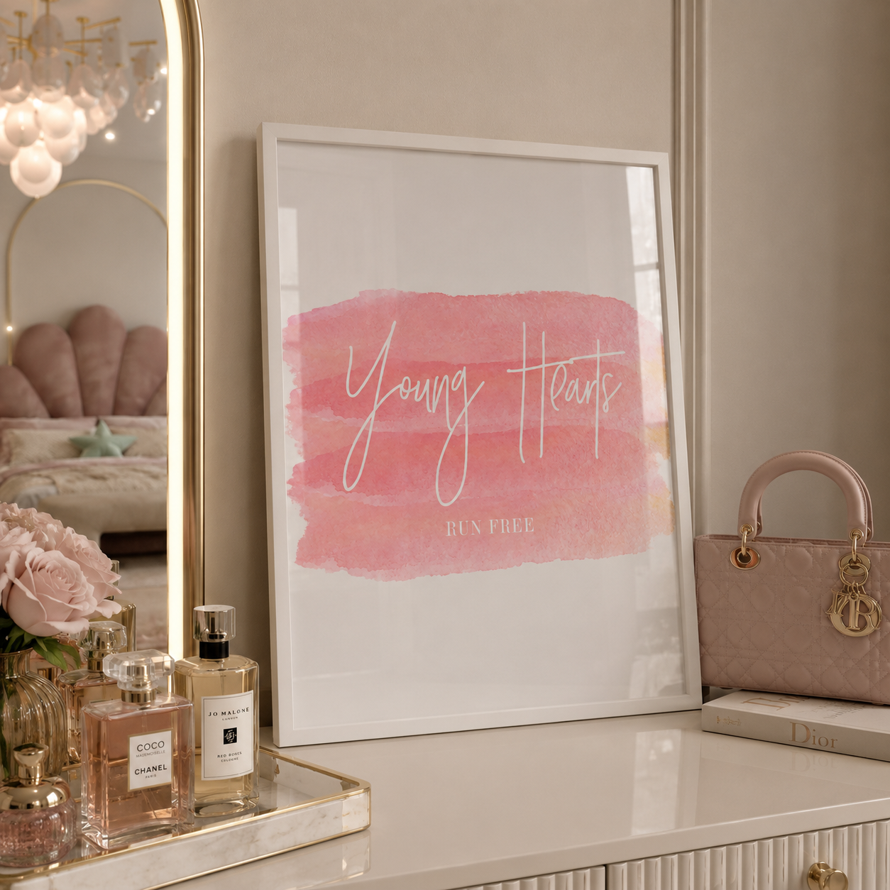 Decorative setup with a framed print, perfume bottles, and a handbag on a surface.