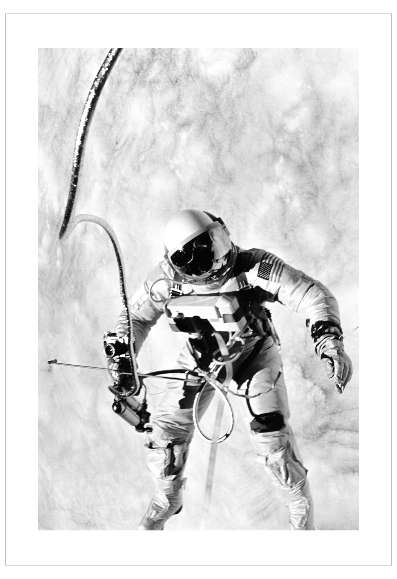 Black and white photograph of an astronaut in space suit with equipment on a white background
