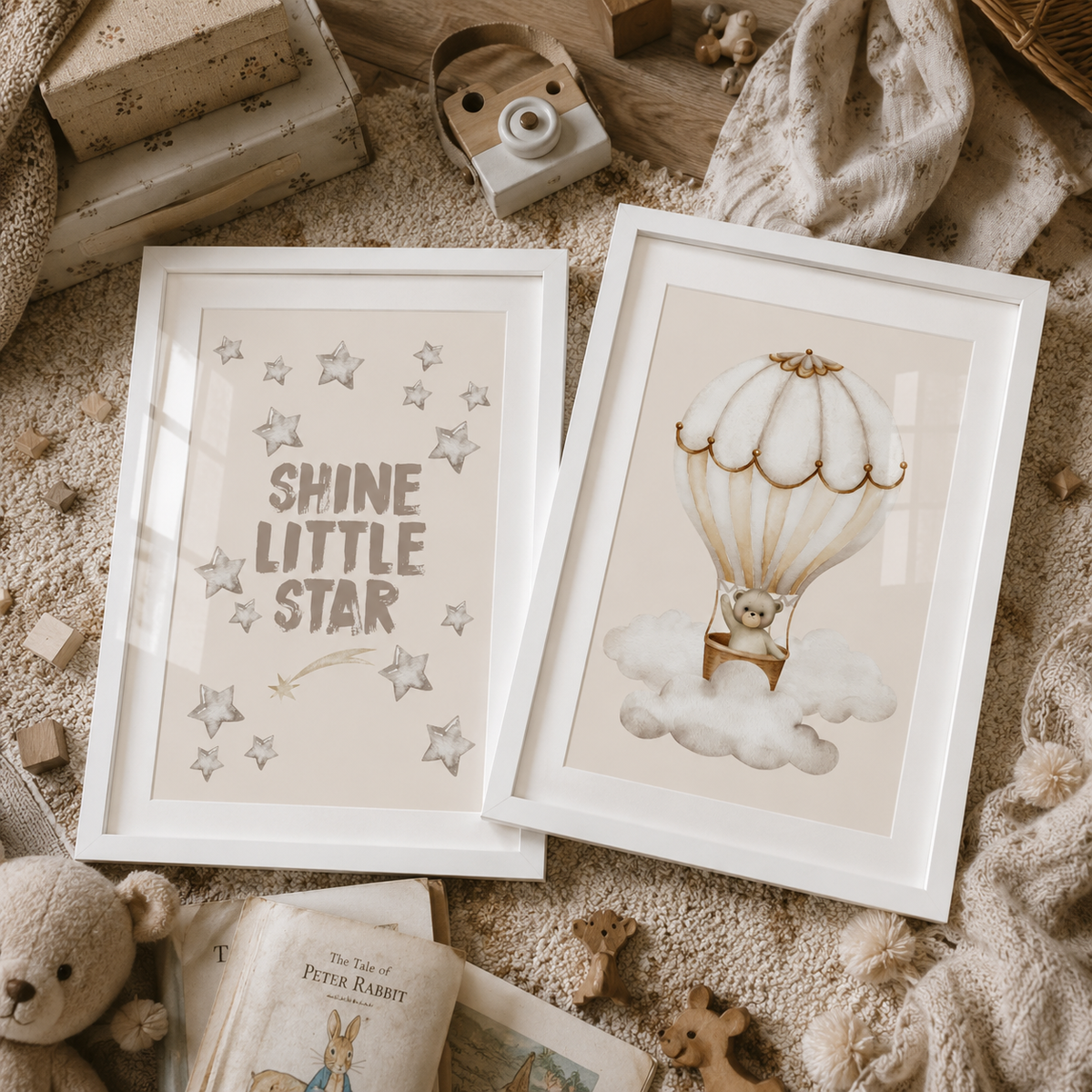Two framed children's art prints displayed on a cozy knitted blanket with nursery props. The left print says 'SHINE LITTLE STAR' with gray stars and a small shooting star.