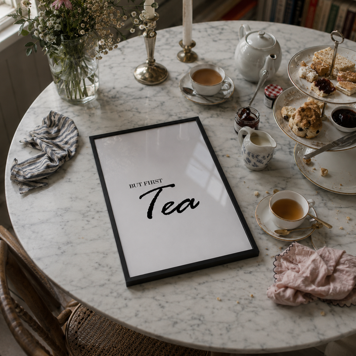 Tea time setting with a 'But First, Tea' sign on a marble table.