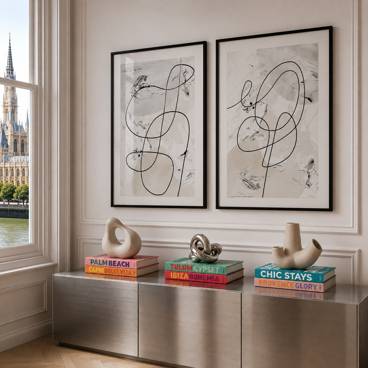 Modern interior with abstract art, books, and sculptures on a metallic console table.