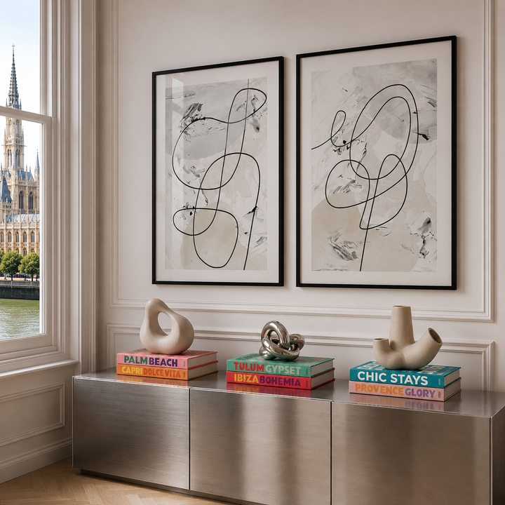 Modern interior with abstract art, books, and sculptures on a metallic console table.