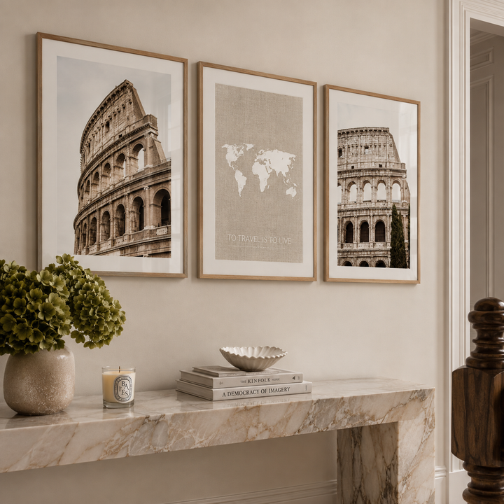Three framed sepia-toned wall art prints featuring the Colosseum and a world map are displayed above a marble console table in a styled interior setting.