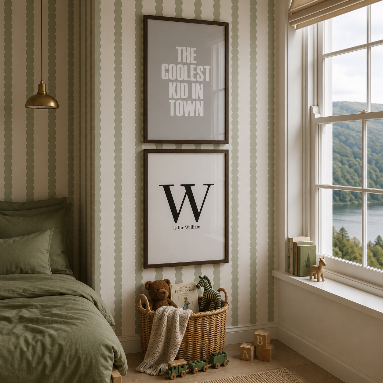 A styled children's bedroom corner with green striped wallpaper, a bed, a window with a lake view, and two framed wall prints hanging above a wicker basket with toys.
