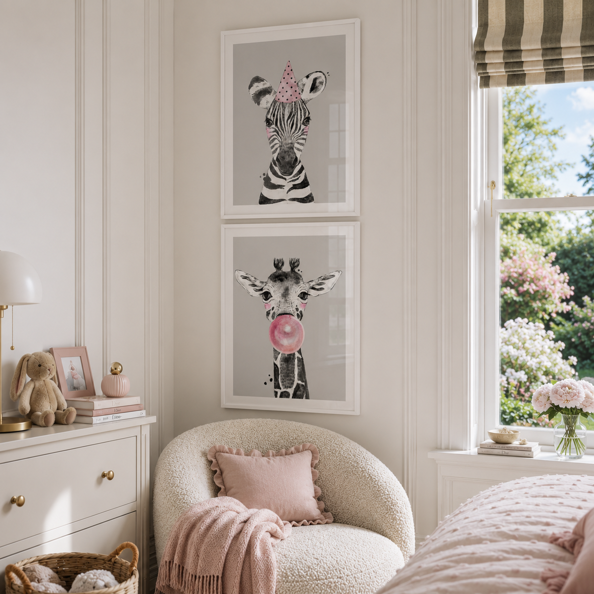 A styled children's bedroom corner featuring two framed animal art prints hanging on a cream wall above a textured cream boucle chair. The top print shows a zebra wearing a pink party hat, and the bottom print shows a giraffe with a pink bubblegum bubble.