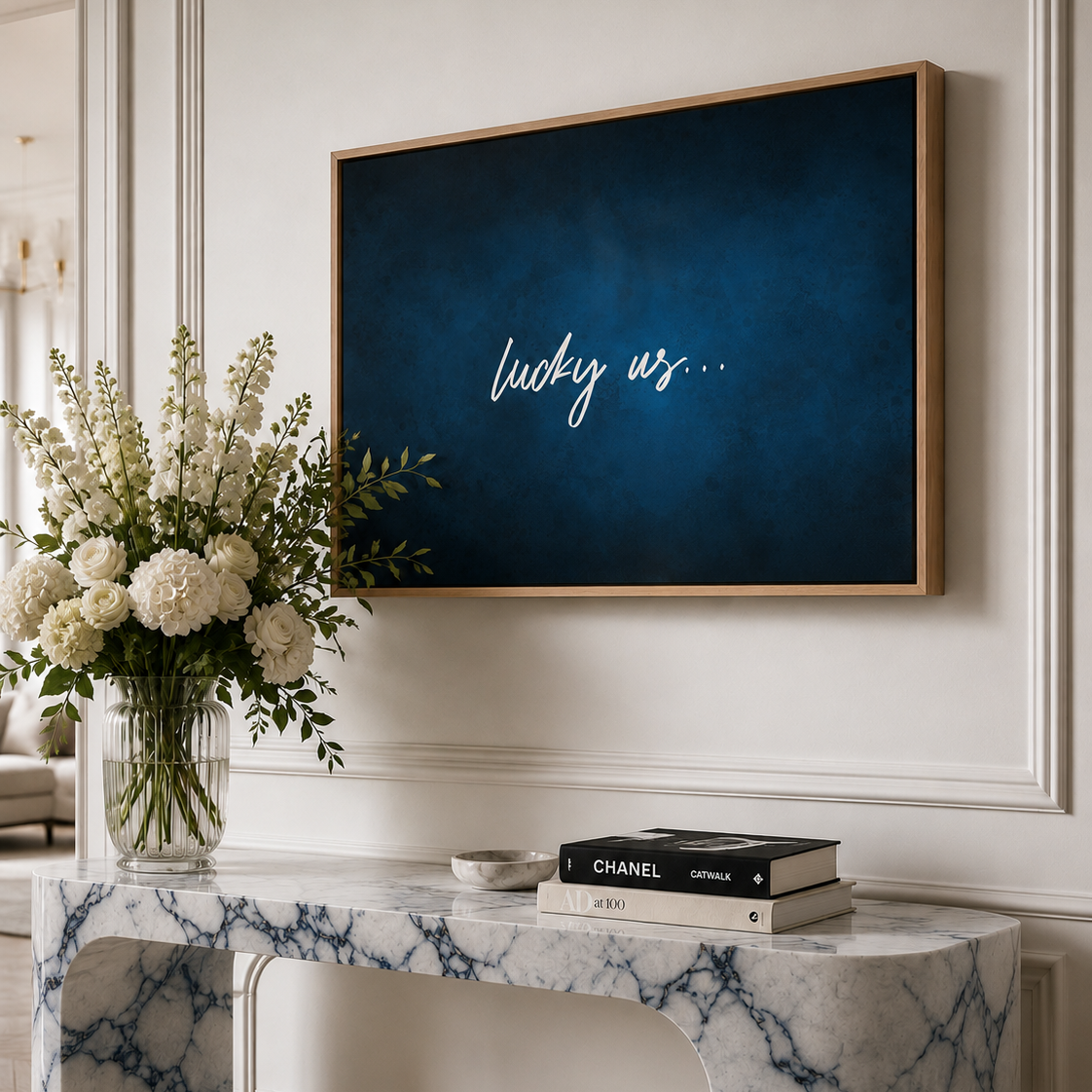 A large framed canvas wall art print with a dark blue textured background and white script text reading 'lucky us.