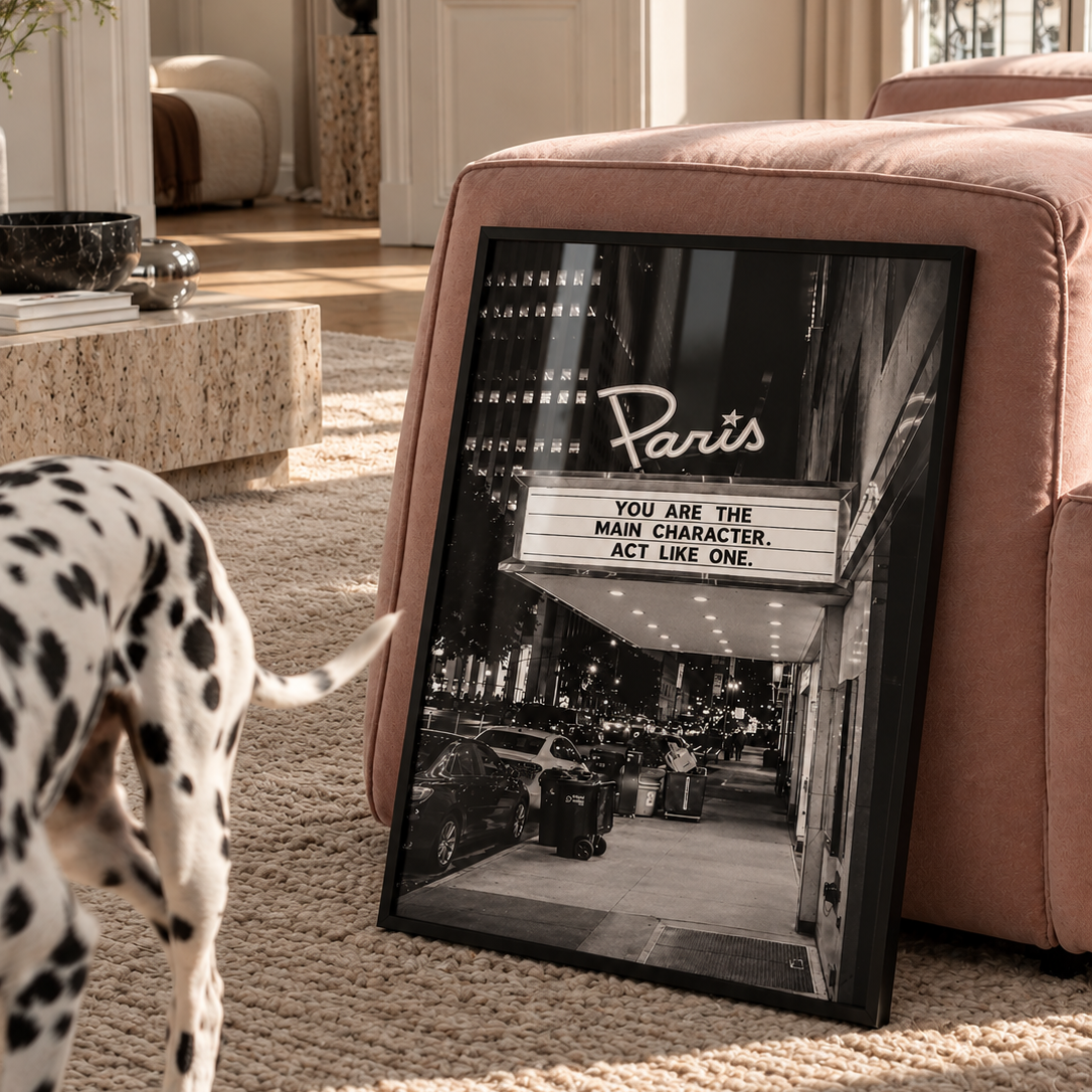 Black and white photograph of a Paris-themed movie theater marquee at night, with the sign reading 'YOU ARE THE MAIN CHARACTER. ACT LIKE ONE.