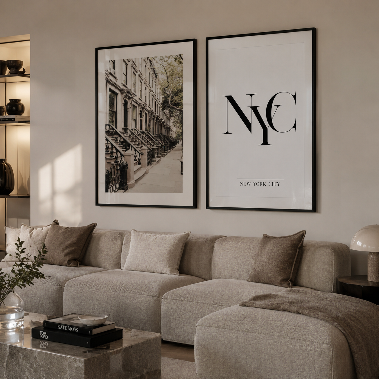 Two framed wall art prints hanging above a beige sectional sofa in a modern living room. The left print is a black-and-white city street scene, and the right print features large black 'NYC' lettering with 'NEW YORK CITY' beneath it on a white background.