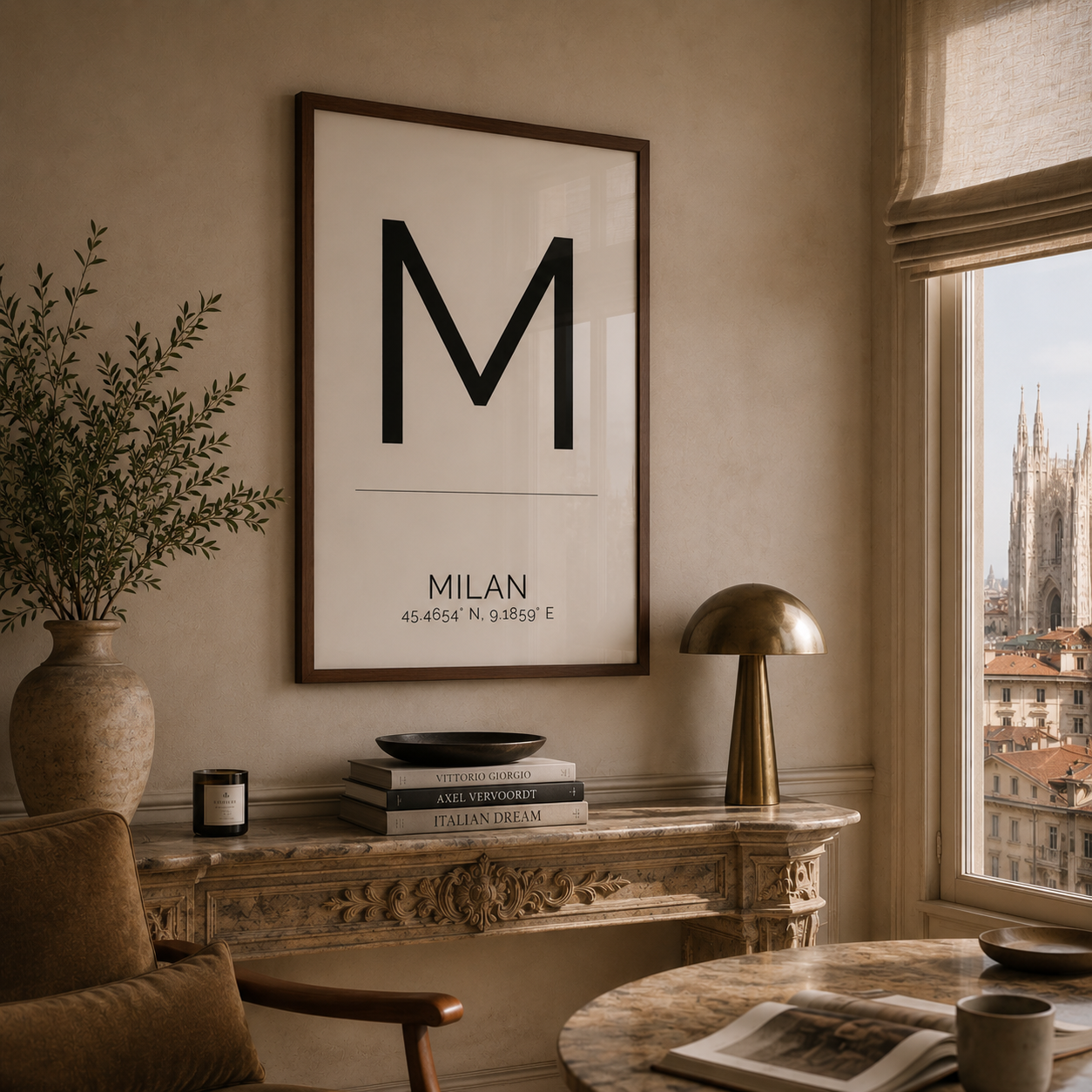 A framed minimalist art print featuring a large black letter 'M' and the text 'MILAN' with coordinates, hanging on a beige wall above a console table in a styled interior room.