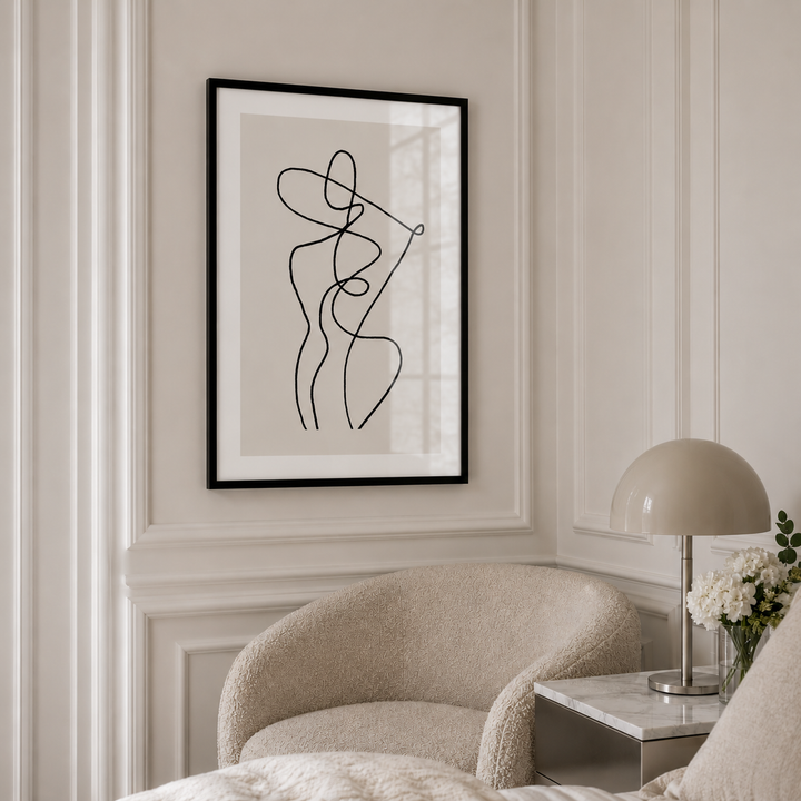 Framed abstract art on a wall above a chair in a room with neutral decor.