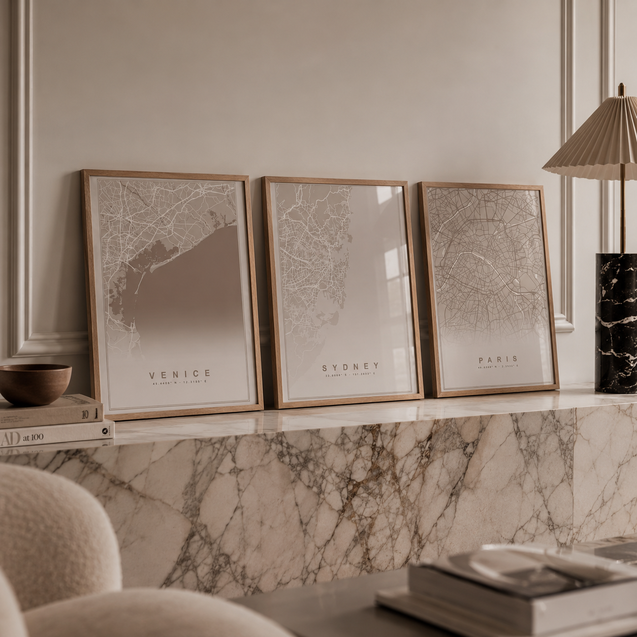 Three framed minimalist city map prints labeled Venice, Sydney, and Paris, displayed side-by-side on a marble mantel in a styled interior setting.