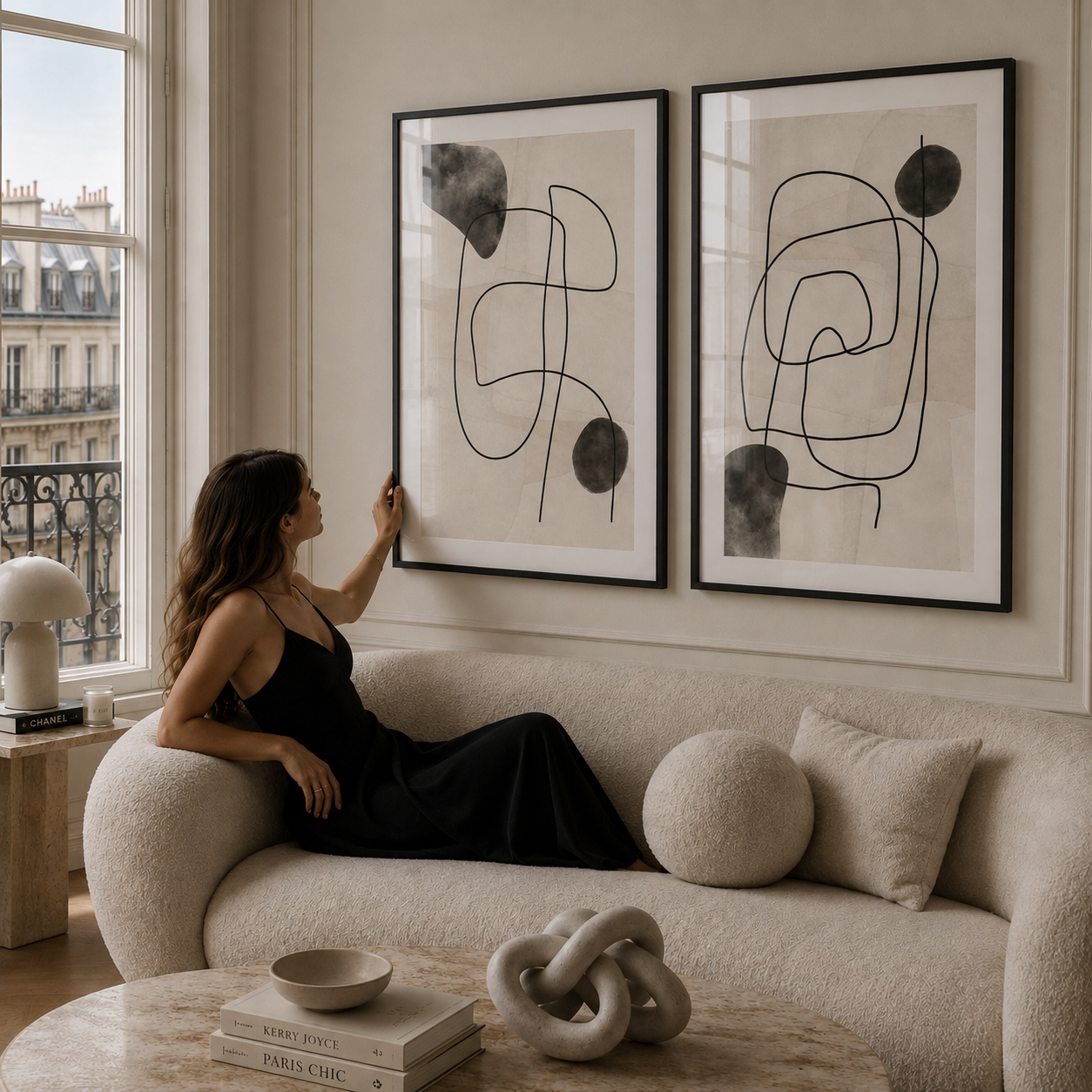 Woman sitting on a couch in a stylish living room with abstract art on the wall.