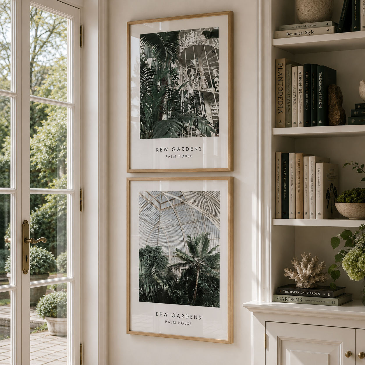 Two framed botanical art prints of Kew Gardens Palm House hanging on a cream wall next to a bookshelf.