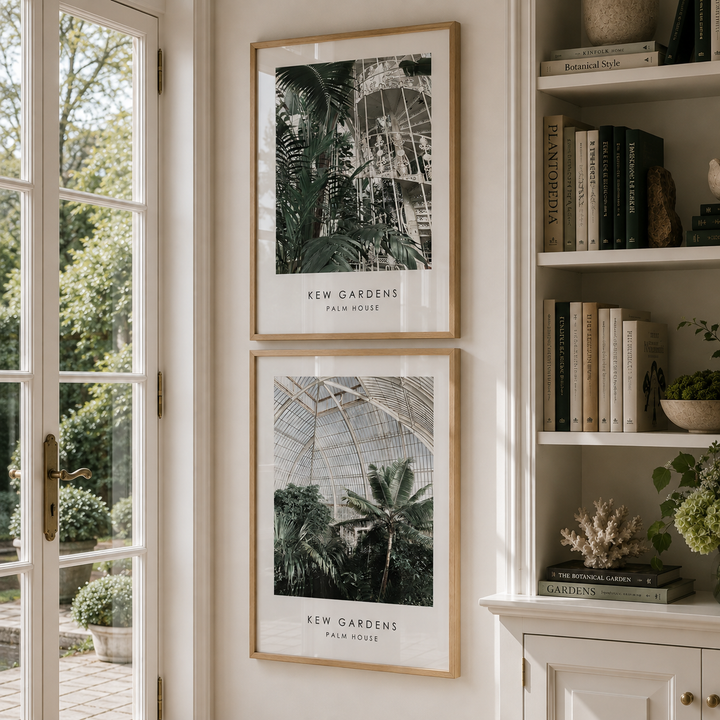 Two framed botanical art prints of Kew Gardens Palm House hanging on a cream wall next to a bookshelf.
