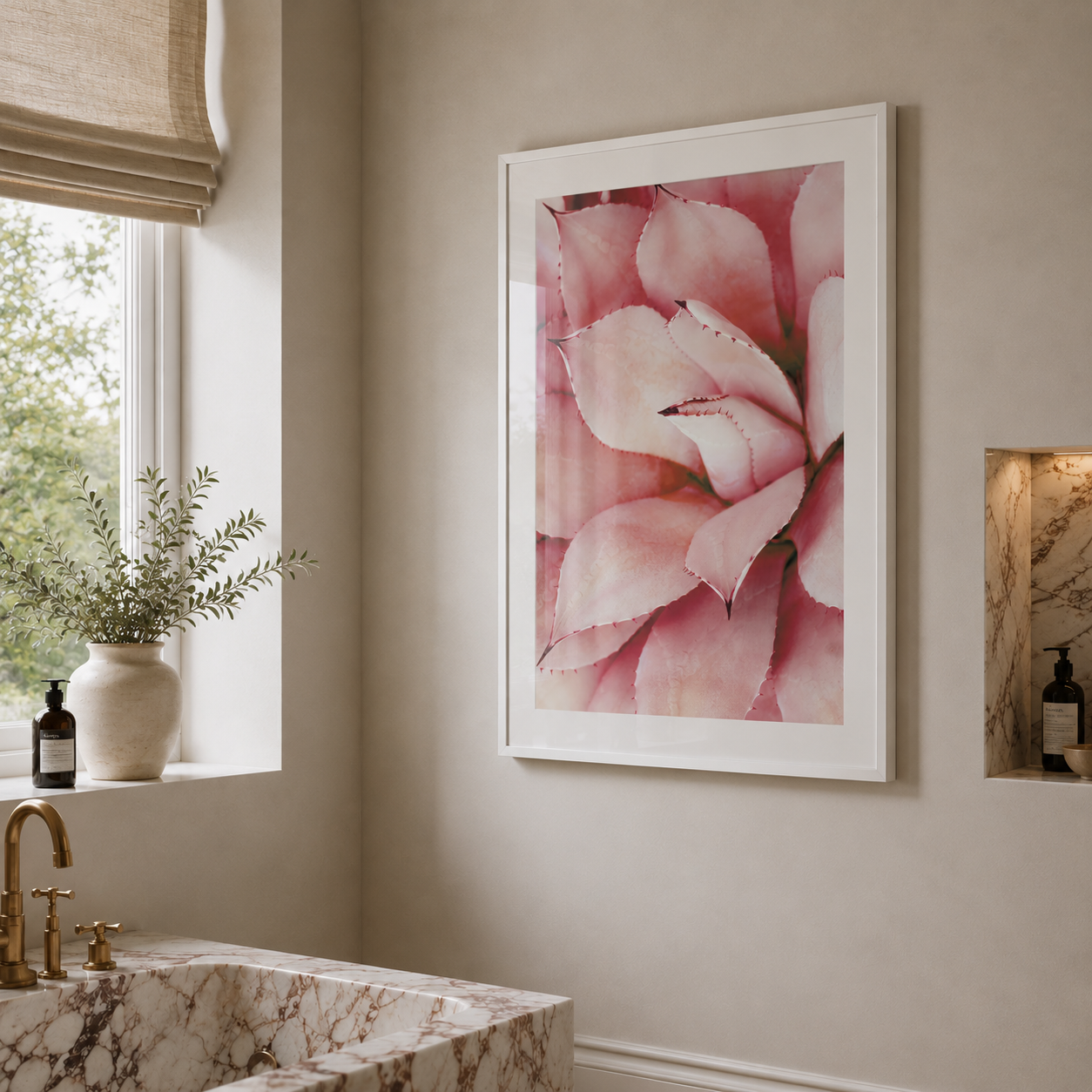 A framed wall art print featuring a close-up pink flower, displayed in a modern bathroom setting with a marble sink, window, and beige walls.