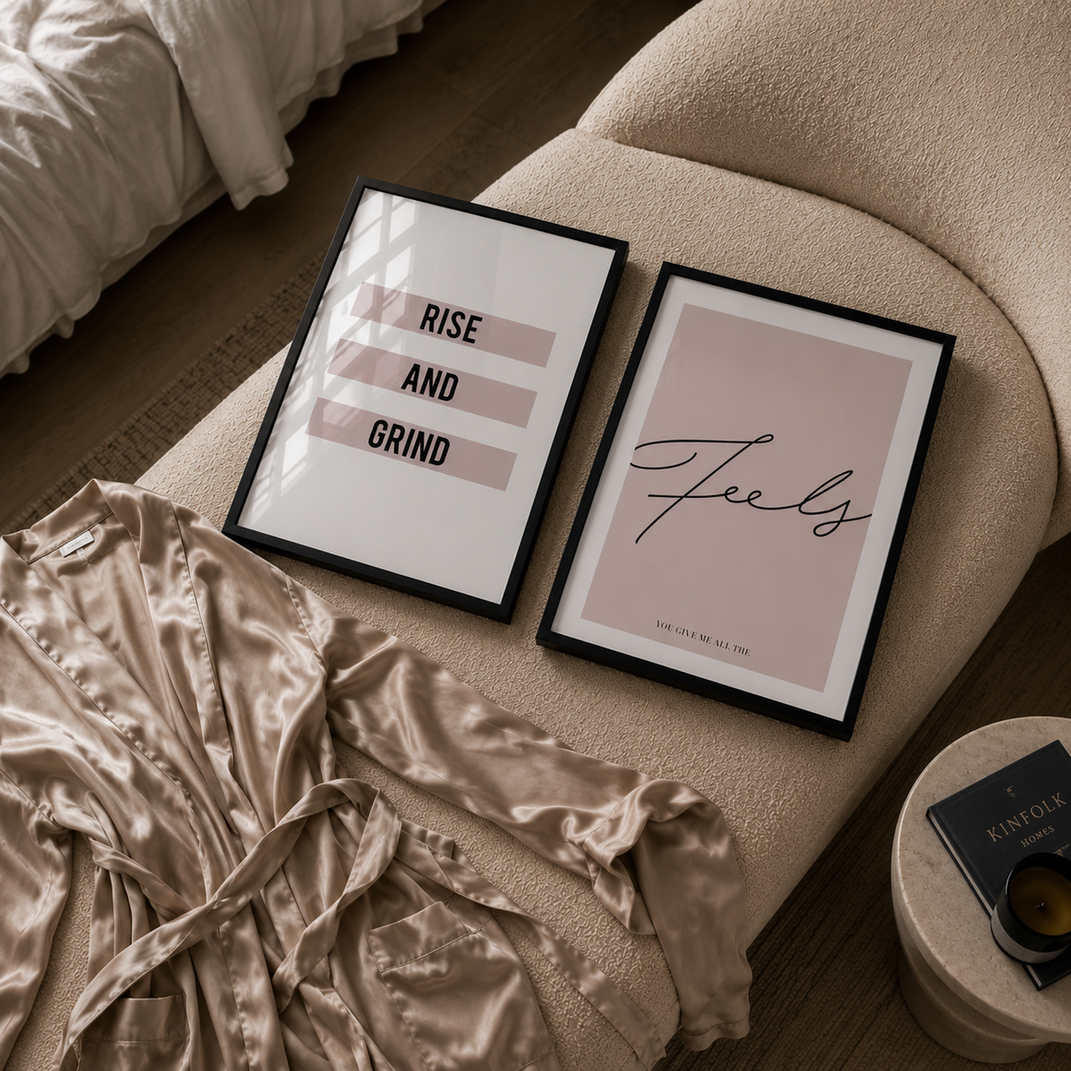 Framed prints on a bed with a robe and nightstand in the foreground