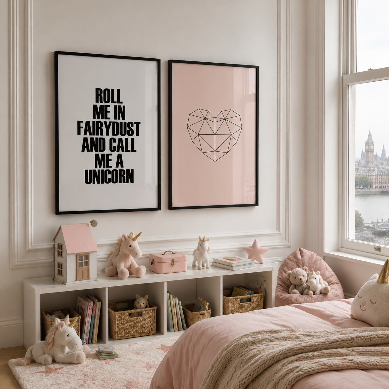 A styled children's bedroom corner with two framed wall prints above a white shelf. The left print says 'ROLL ME IN FAIRYDUST AND CALL ME A UNICORN' in black text on white, and the right print shows a geometric heart line drawing on soft pink.