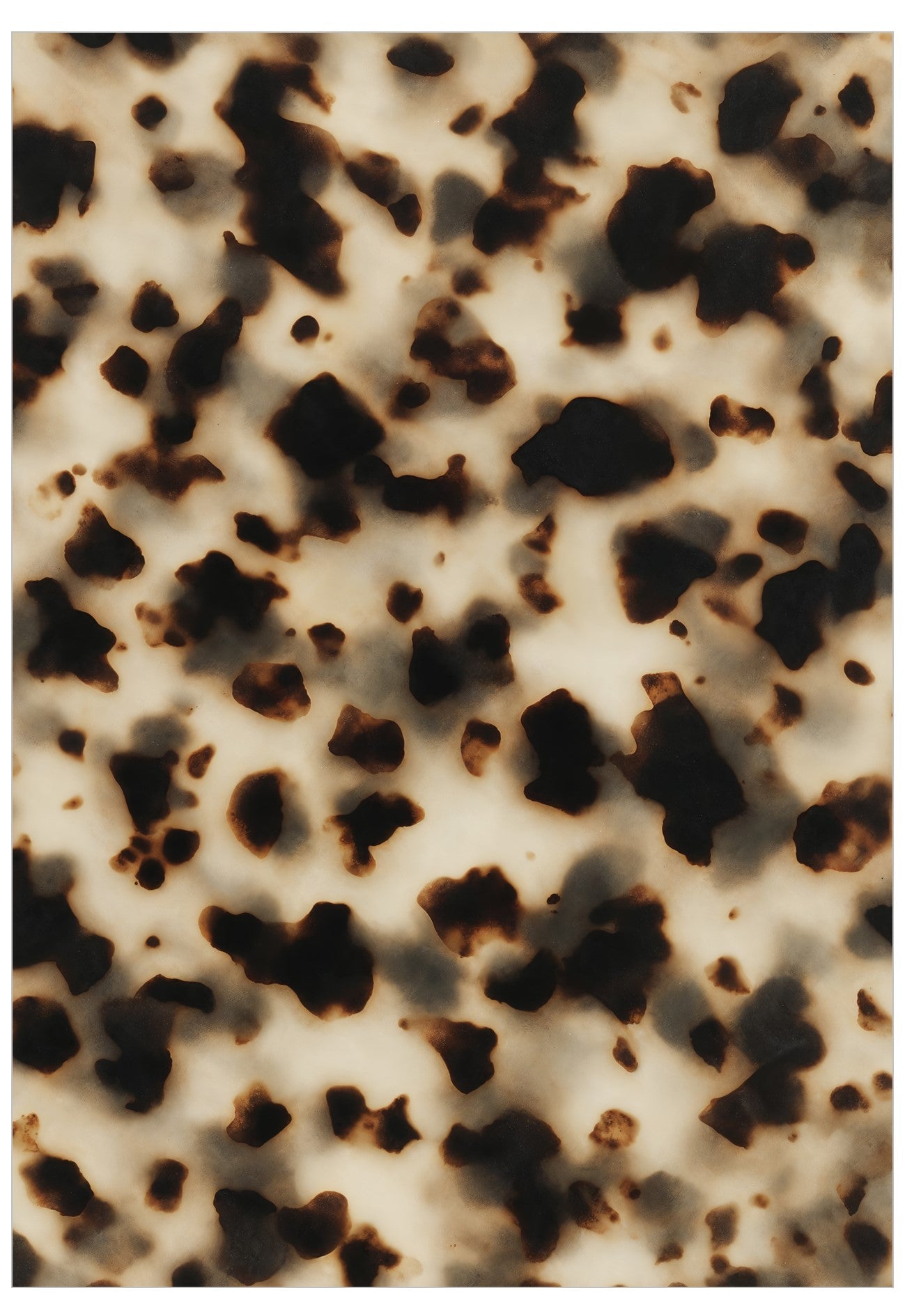 A close-up of a tortoise shell print pattern featuring dark brown and black irregular spots on a warm beige background.