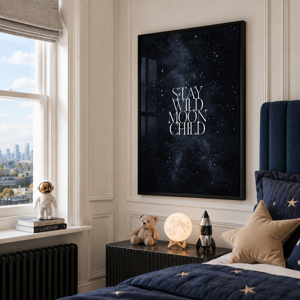 A framed vertical wall art print with the phrase “STAY WILD MOON CHILD” in white serif text over a dark starry night sky, displayed in a styled bedroom above a bedside table.