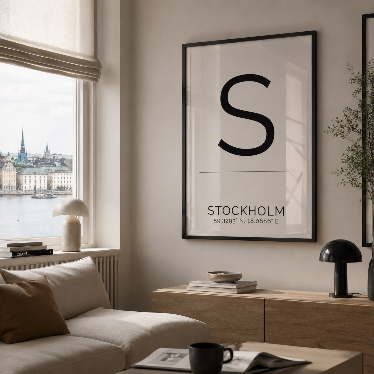 A minimalist framed poster featuring a large black letter 'S' and the text 'STOCKHOLM' with coordinates, hanging on a beige wall in a modern living room with a sofa, window view, and wooden console.