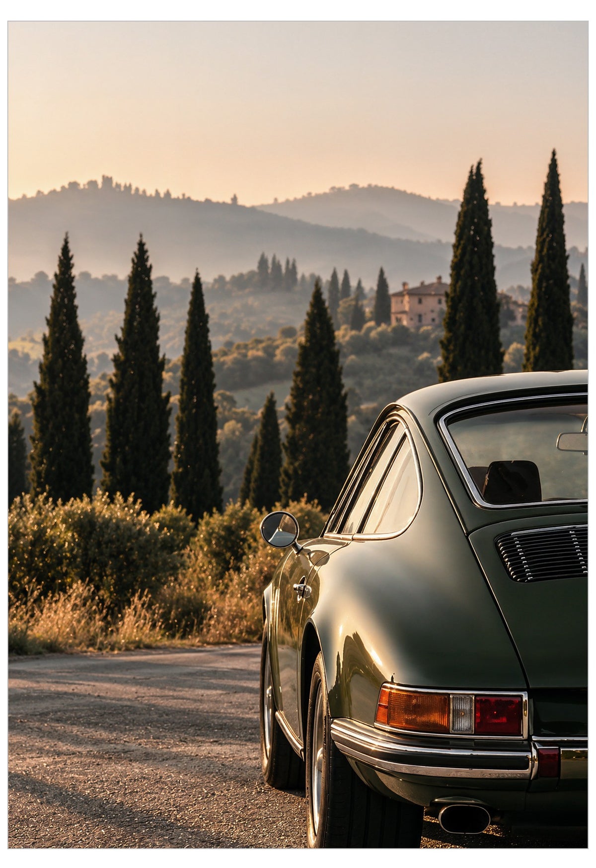 A dark green classic Porsche 911 coupe parked on a sunlit country road with cypress trees and rolling hills in the background.