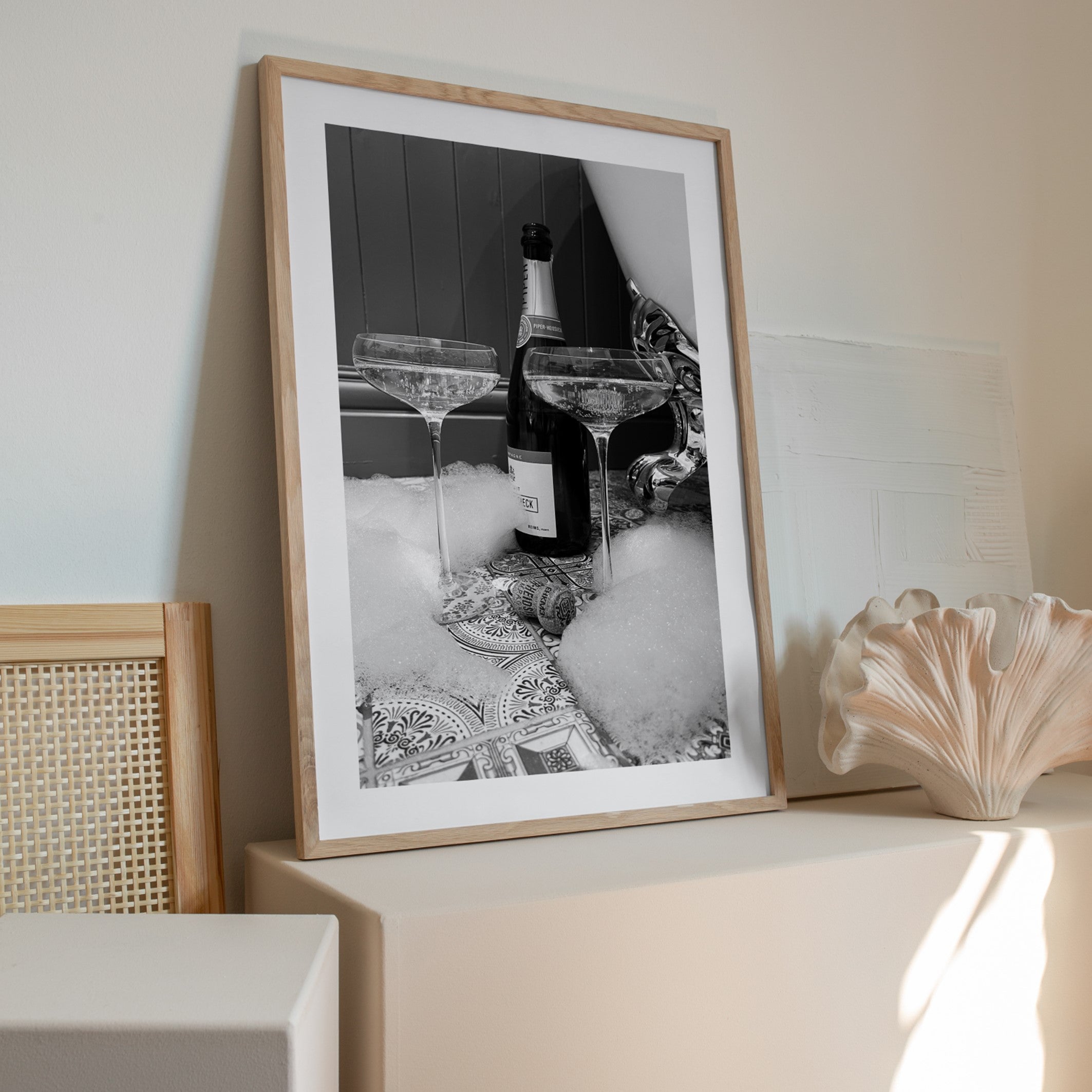 champagne bottle with two glasses next to a roll top bath