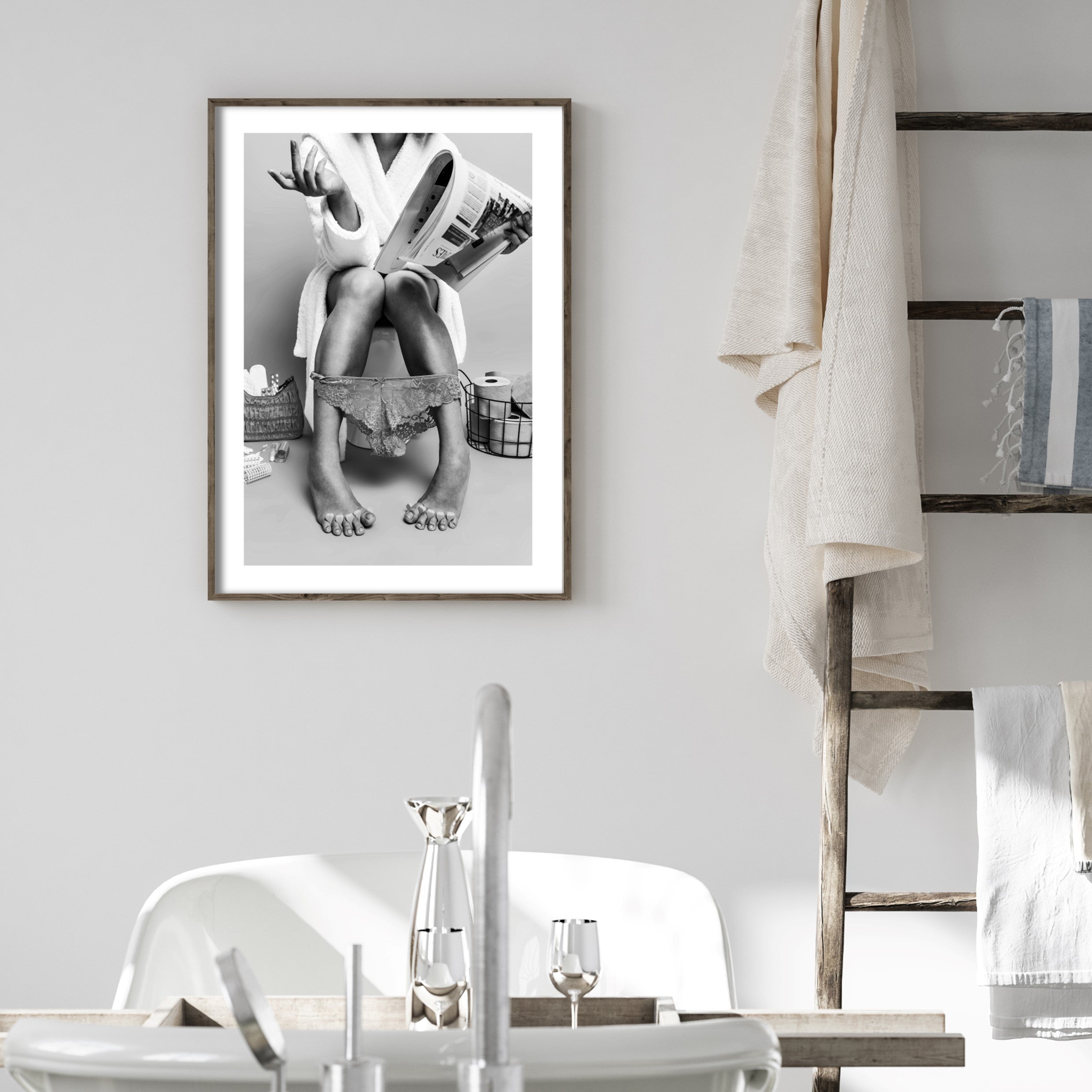 Framed bathroom poster of a woman sitting on a toilet reading a newspaper